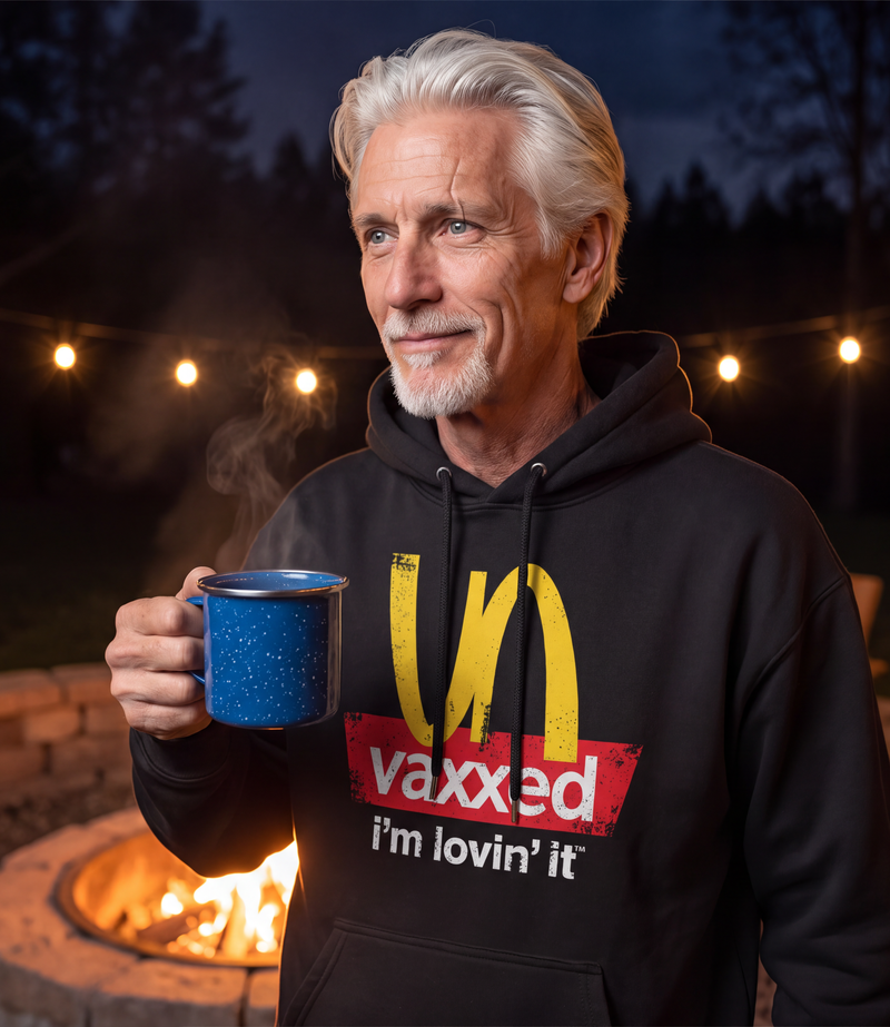 Man wearing the black Unvaxxed Hoodie at a backyard fire pit