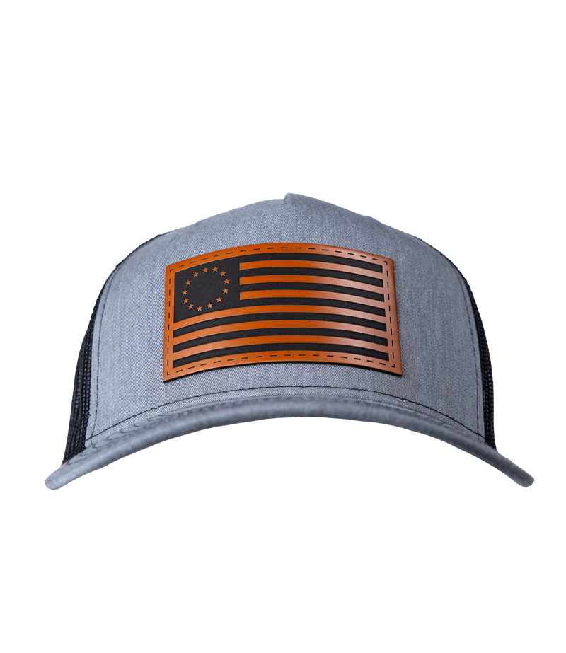 The Alex Jones Store - Heather grey American Flag leather patch trucker hat with Betsy Ross 13-star flag patch and black mesh back