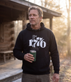 Man wearing The Answer To 1984 Is 1776 Hoodie in black at a cabin porch at dawn