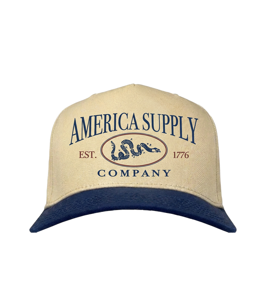 The Alex Jones Store - Tan and navy two-tone America Supply Co. 'Est. 1776' Trucker Hat with rattlesnake oval logo, front view