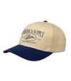 The Alex Jones Store - Tan and navy America Supply Co. 'Est. 1776' Trucker Hat with rattlesnake oval logo, side-angle showing curved navy bill