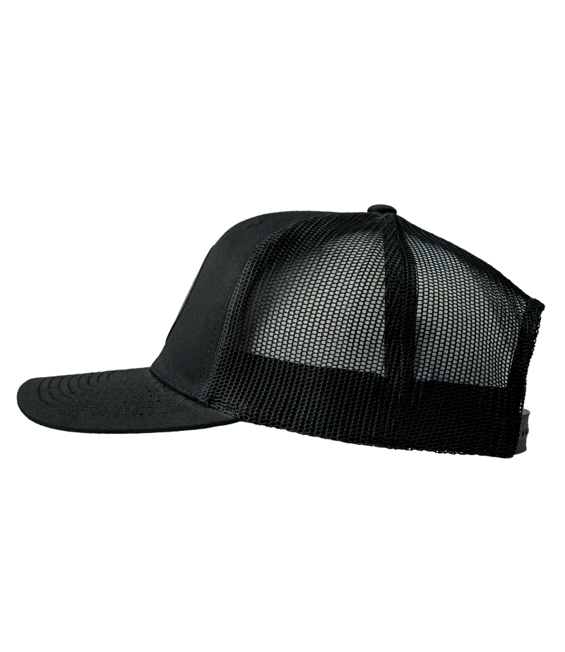 The Alex Jones Store - Obedience To God Circle Star Leather Patch Hat — Left side view of black mesh-back trucker hat with leather patch design partially visible