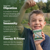 Child holding a Kids Greens Gummies pouch, with digestion, immunity and energy benefits listed