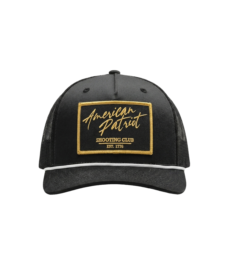 The Alex Jones Store - Front of black American Patriot Shooting Club hat with gold-bordered stitched patch, white rope and black mesh back
