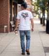The Alex Jones Store - Man walking away in white America 250 Flying Eagle t-shirt back print, paired with Betsy Ross flag cap and jeans